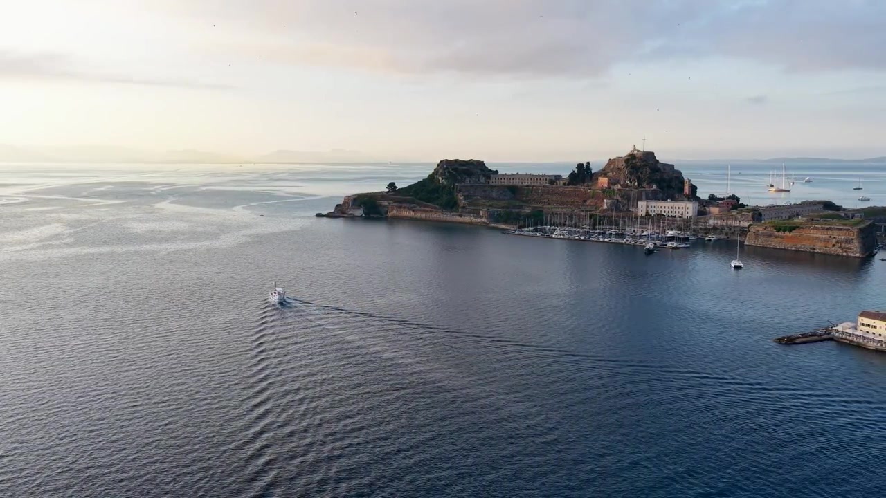 Vista aerea di una barca che naviga verso la Vecchia Fortezza a Corfù, Grecia. Storico castello veneziano su una penisola rocciosa circondato dal Mar Ionio