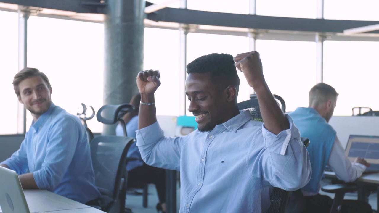 Happy African American Businessman Celebrating Success in Modern Office