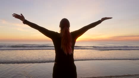 woman-spreads-her-arms-and-watching-the-sunrise-while-breathing-during-sunrise
