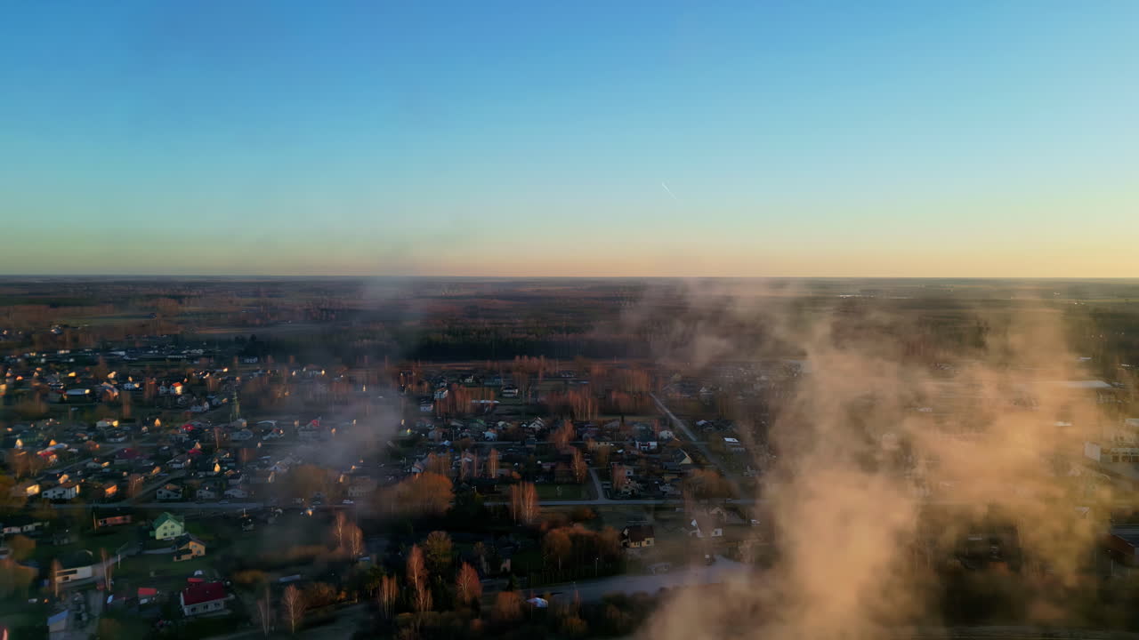 Veduta aerea di fumo sfumato al tramonto sotto una città americana, con orizzonte dello skyline ripreso da drone, case e nuvole di nebbia, come una vista rotante dall'alto