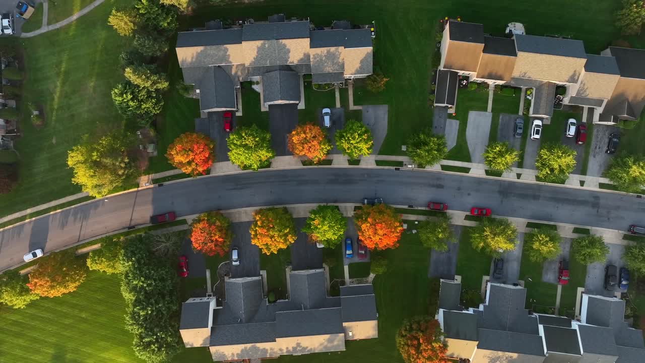 Aerial drone view of American suburban neighborhood with digital smart home icons and data network overlay representing IoT connectivity and power grid innovation