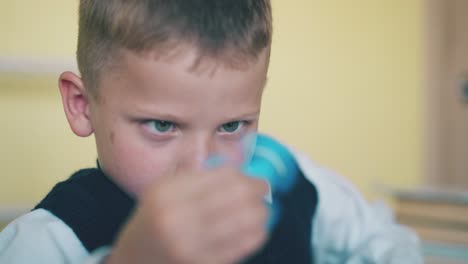 schoolboy plays with turning toy at break in classroom
