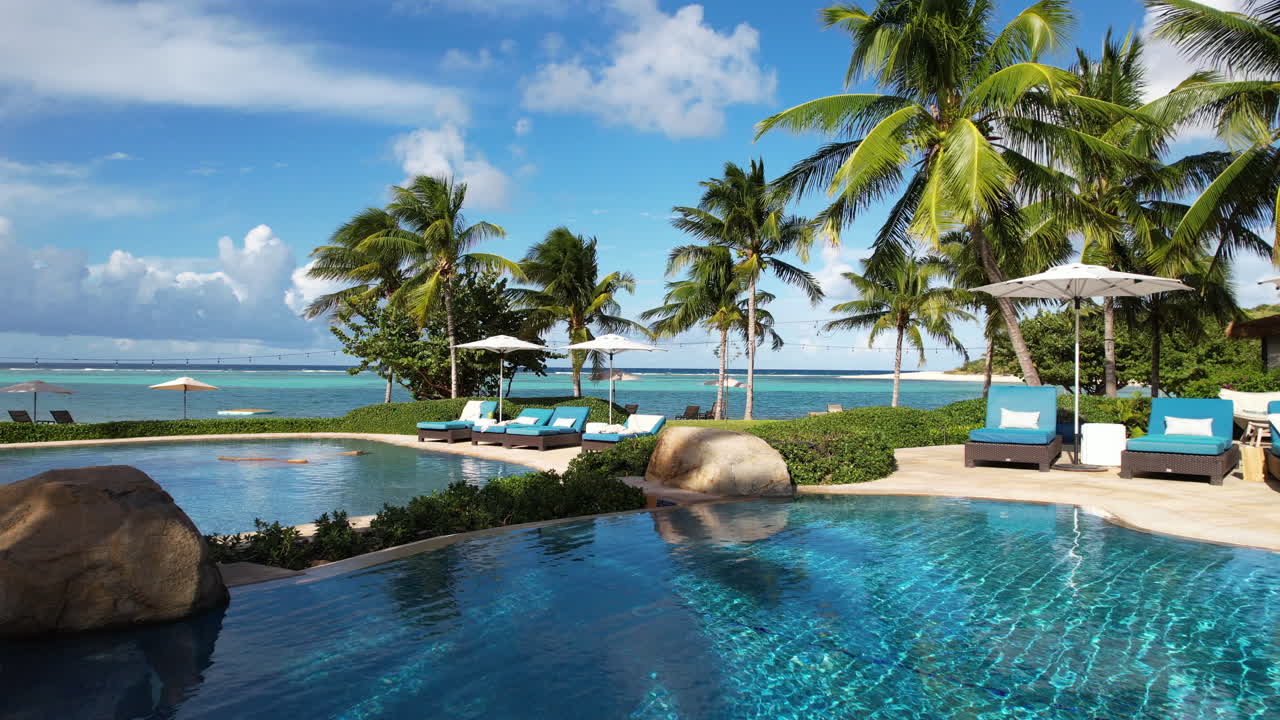 Luxury tropical resort, flying above swimming pools with view of exotic ...