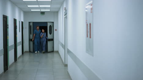 Colegas-Médicos-Saliendo-De-La-Sala-De-Emergencias-Discutiendo-La-Pandemia-De-Covid.