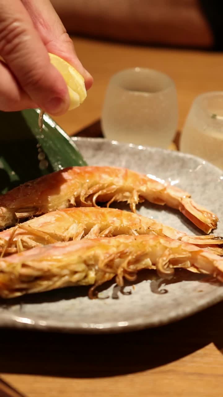 식탁 에서 레몬 을 넣은 생선 을 맛보는 사람