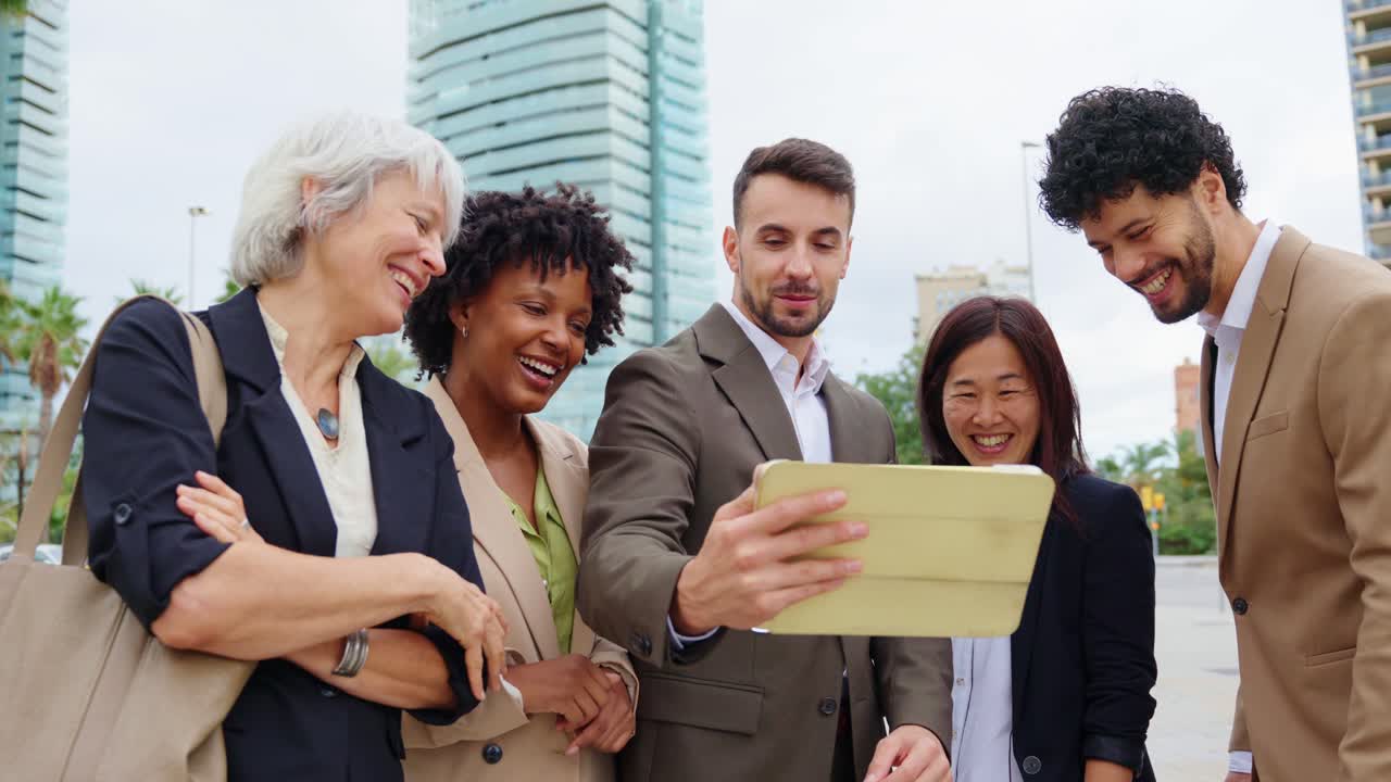 Diverse business team collaborating on a tablet outdoors