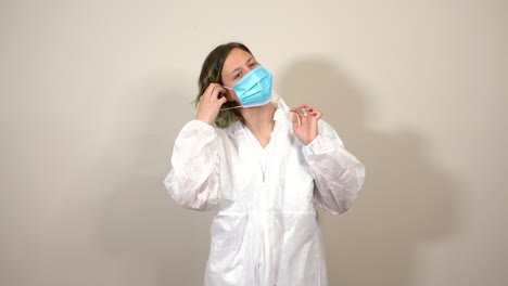 female doctor putting on the mask and ppe suit hood in front of the camera