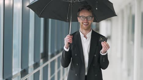 portrait of a happy business man with an umbrella and a plastic briefcase in his hands