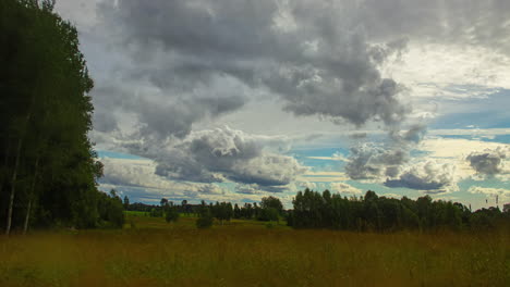 Morning-Sunrise-Timelapse-Over-Grassy-Landscape-with-Sweeping-Clouds-Overhead-in-Latvia