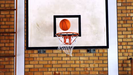 basketball passing through hoop in court