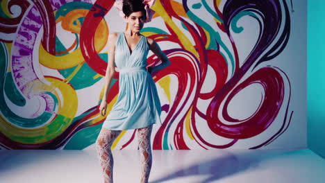 woman in blue dress posing against a vibrant abstract background