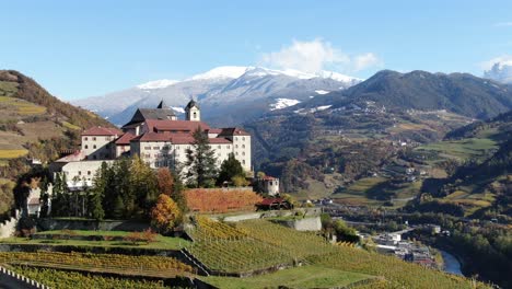 aerial drone over a medieval castle in the middle of the vineyards in italy named salita sabiona