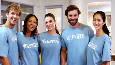 Grupo-De-Voluntarios-De-Pie-Con-El-Brazo-Alrededor