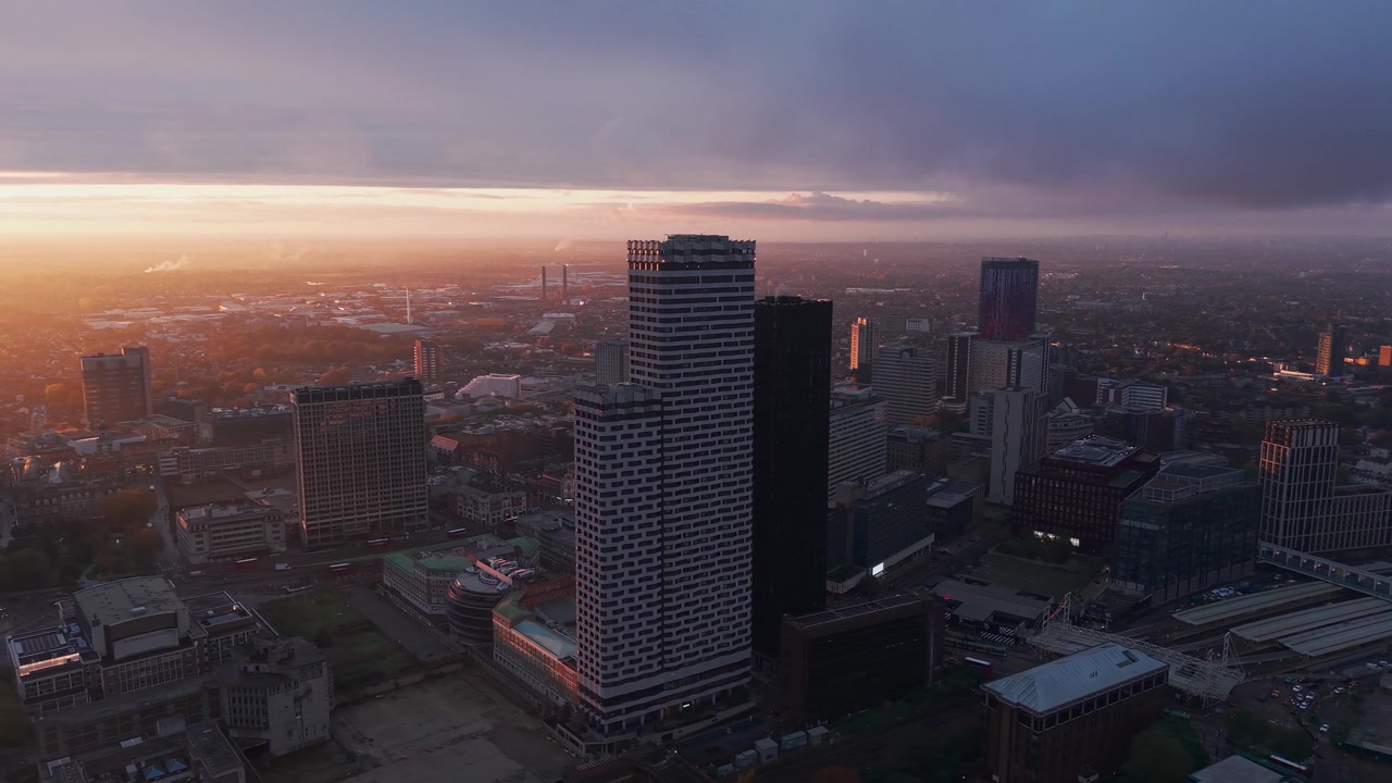 Aerial view across Croydon high rise residential blocks establishing golden hazy morning cityscape