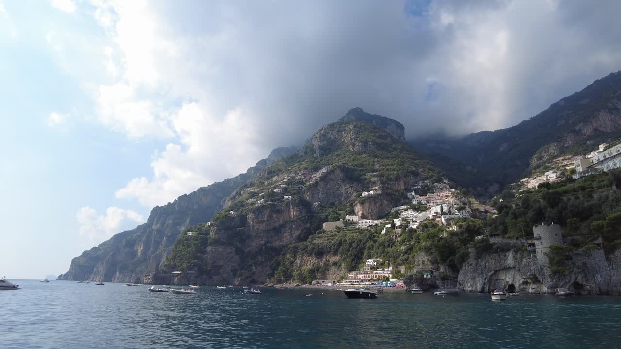 vista desde un barco de las casas construidas en una ladera en la costa de amalfi, italia - ángulo bajo