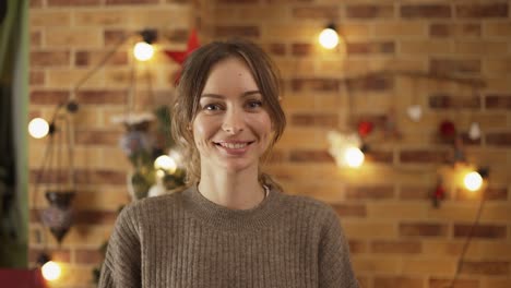 Portrait-of-pretty-adult-girl-standing-at-home-with-Christmas-decoration-on-background