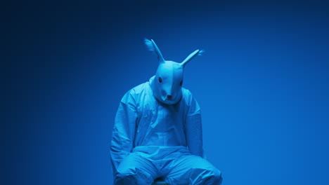 person in rabbit mask and hazmat suit