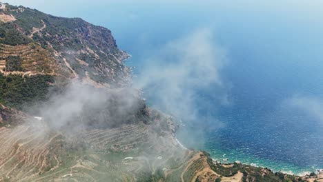 Aerial view of coastal cliffs with terraces and misty ocean view