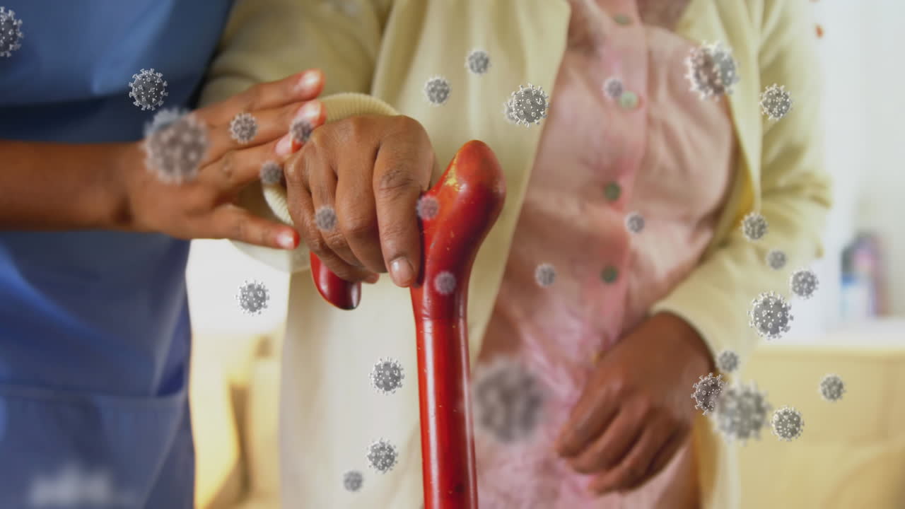 코로나19 백신을 복용한 여성 의료진이 고령 여성이 걸을 수 있도록 도와주고 있다.