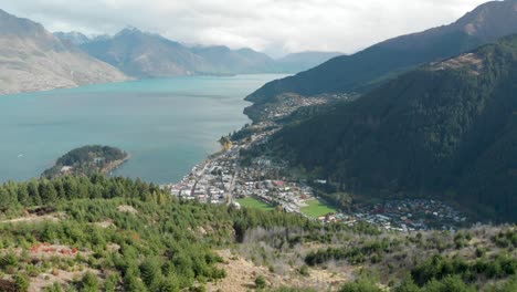 beautiful view of queenstown from queenstown hill track hike, new zealand and lake wakatipu, mountains with fresh snow, clouds and town - aerial drone