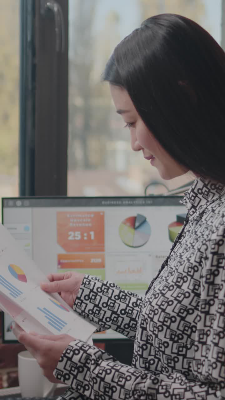 Asian Businesswoman Analyzing Data on Computer