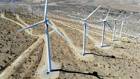 Windmills,-wind-turbines--aerial-4k-drone-slow-pull-back-and-rise,-energy,-green,-renewable,-huge-power-generating-farm-on-desert-hills,-in-Palm-Springs,-Coachella-Valley,-Cabazon,-California