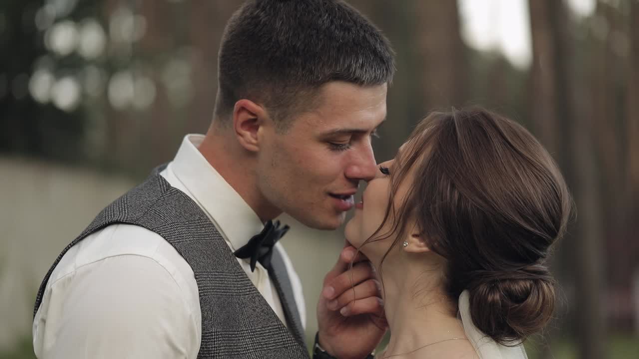 Recién casados, novio caucásico con la novia caminando, abrazándose en el parque, pareja de boda.