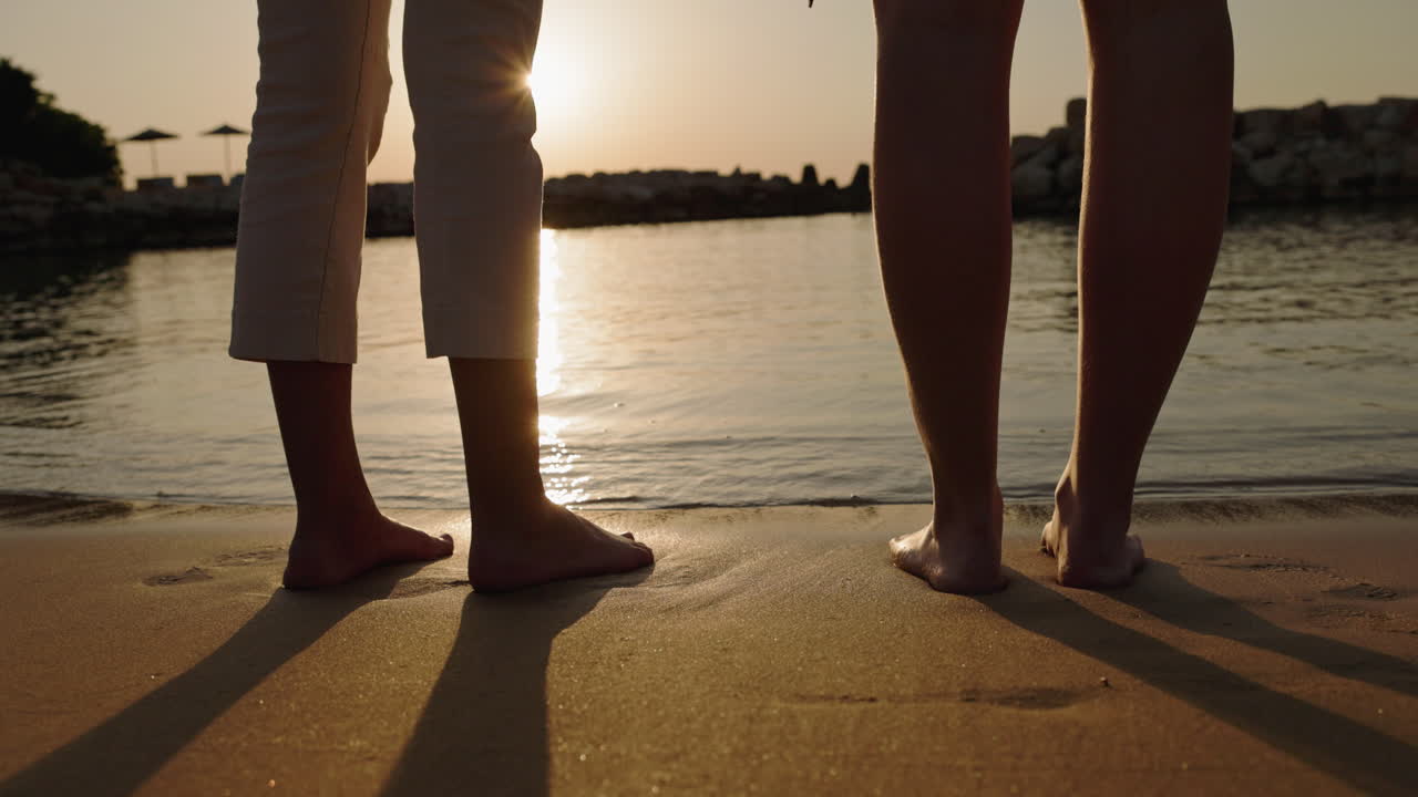 People on a sandy beach at sunset