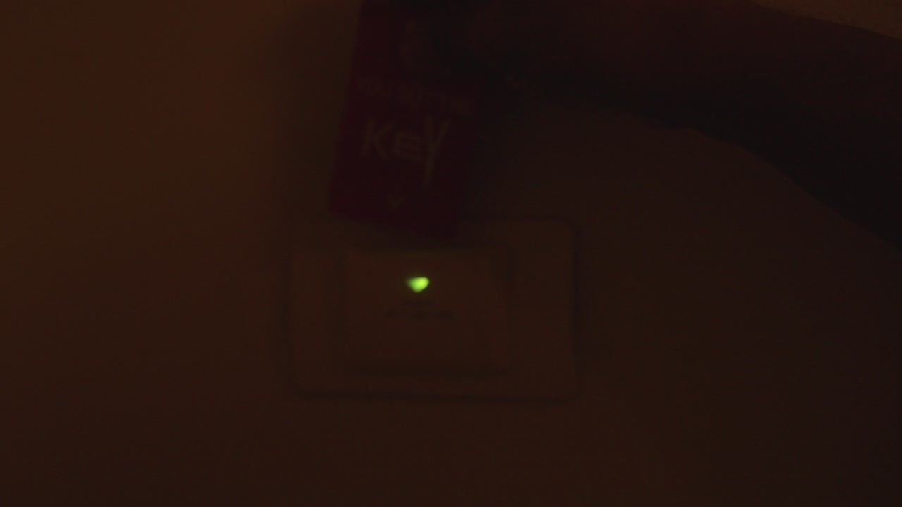 손의 남자가 호텔에서 전력을 열기 위해 근접 카드를 입합니다.