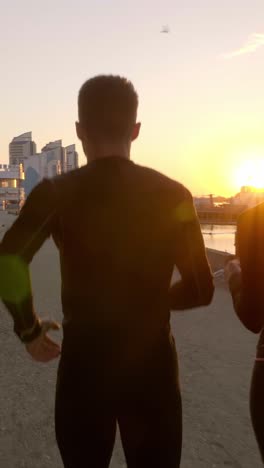 couple running at sunrise/sunset by the river/waterfront