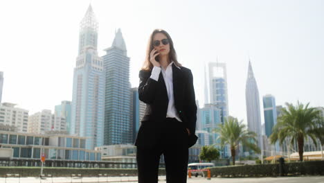 elegant businesswoman with phone outdoors