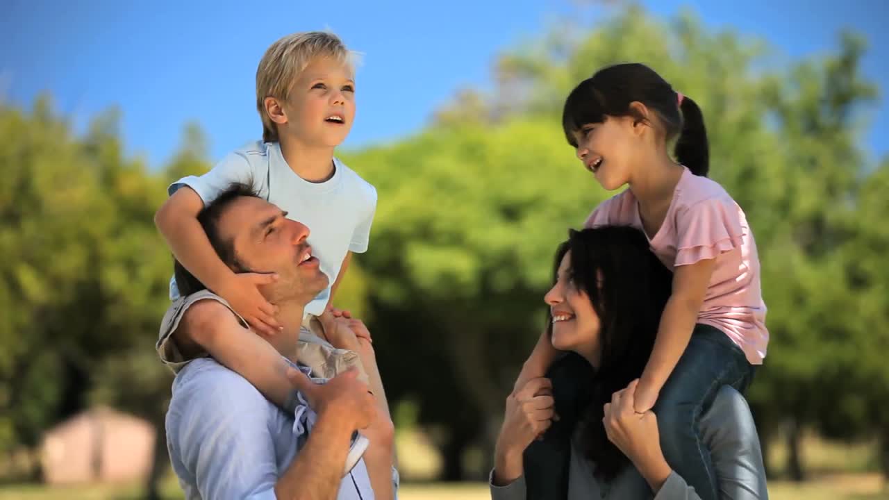 부모님이 자녀를 들고 함께 시간을 즐기고 있습니다.