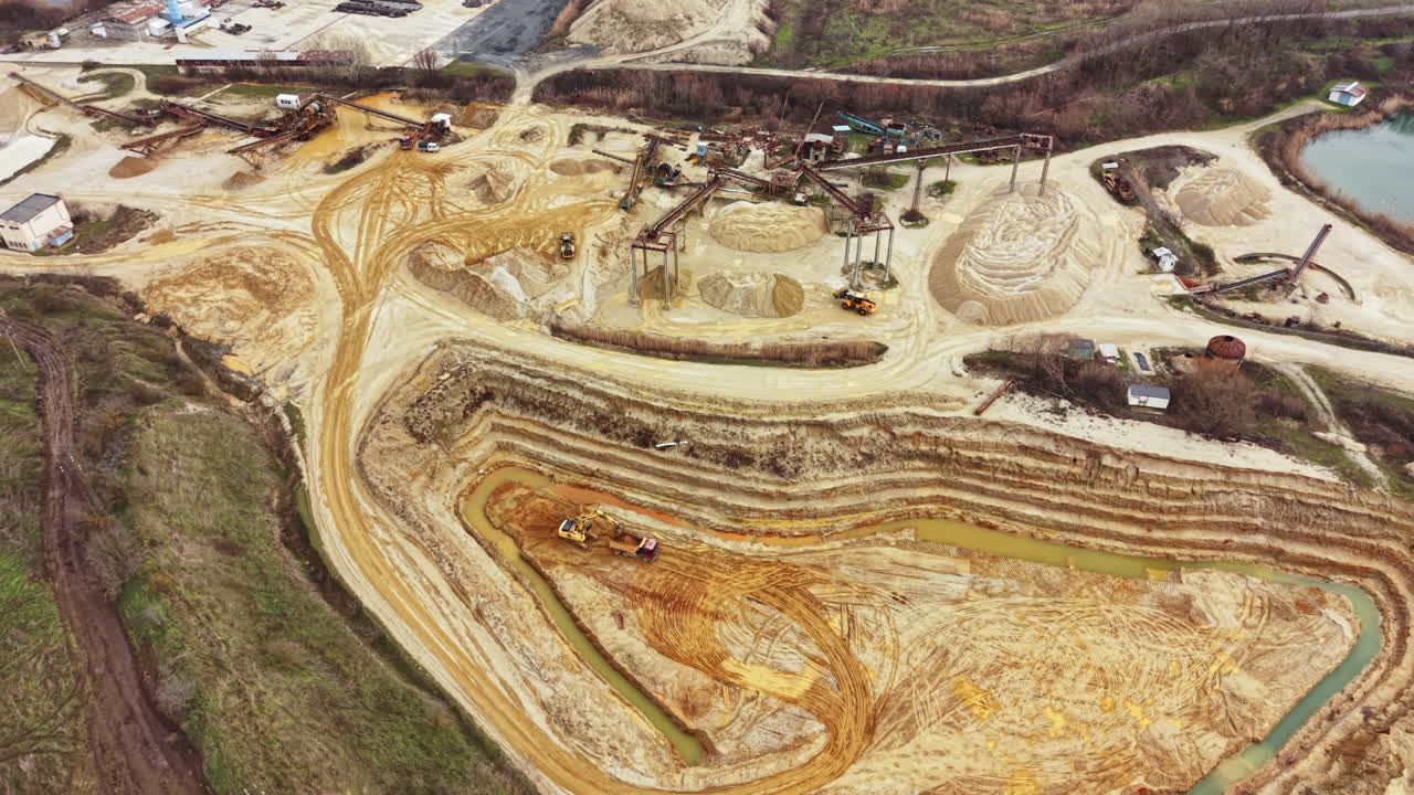 Construction site shows heavy machinery working on land development in a rural area during daylight hours