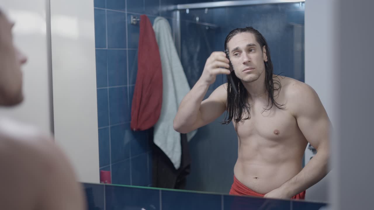 Man combing his wet hair in the bathroom