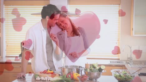 couple having fun and cooking at home with digital hearts