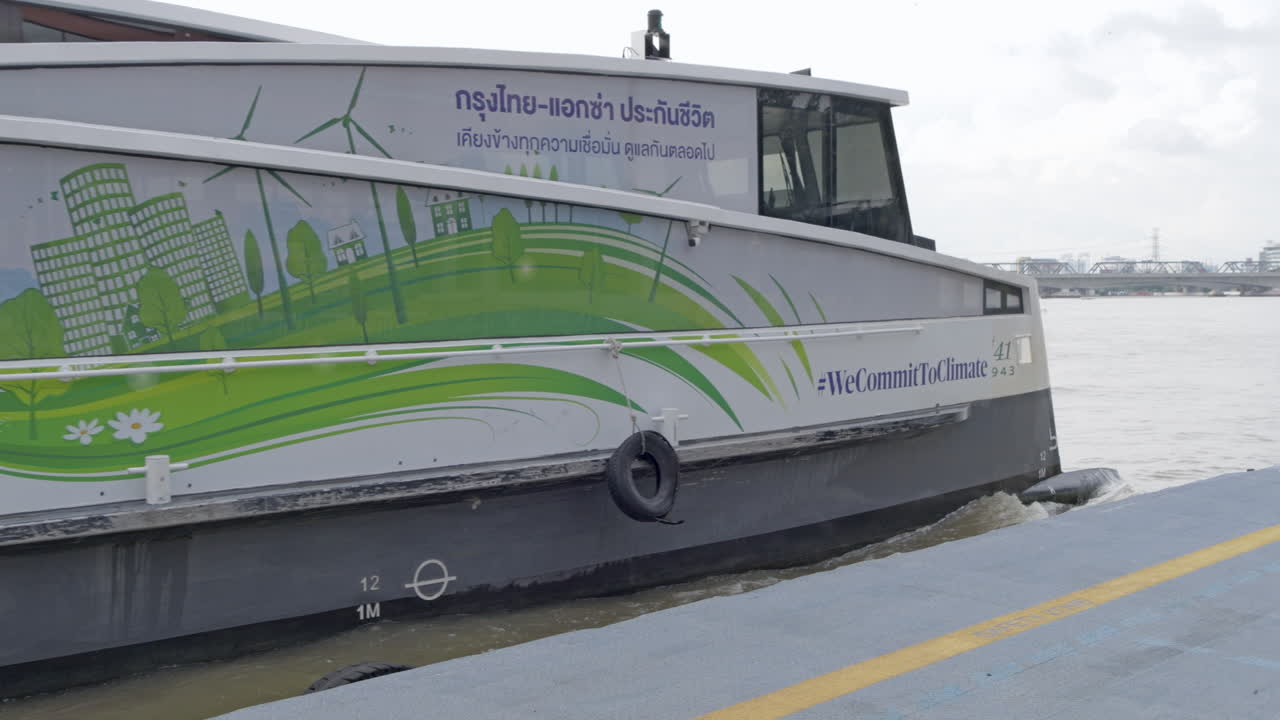 Electric speedboat arriving at the pier in Bangkok for passenger pick-up and drop-off on the Chao Phraya River promoting environmentally friendly transportation options with alternative energy sources