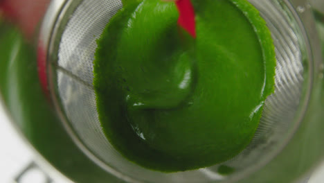 straining spinach puree chutney carefully closeup