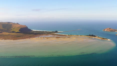 aerial view of a scenic coastal estuary with sandbar and pier