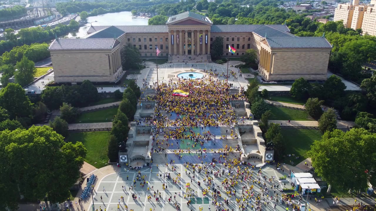 Persone con abiti gialli riunite nell'area della piazza, nota anche come "Rocky Steps", a Philadelphia, Pennsylvania, USA