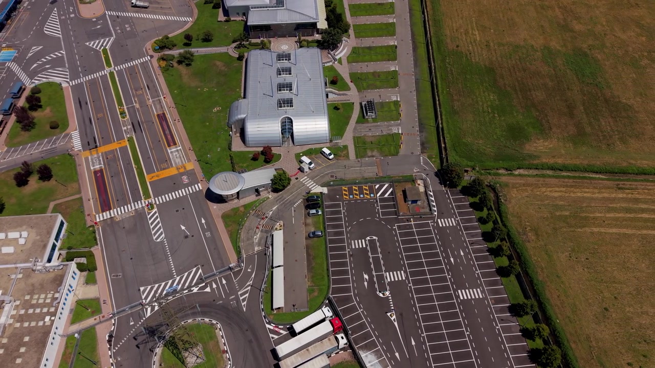 Luftfoto af industrianlægs indgang og parkeringsområde
