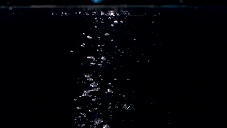 abstract stones falling into water in slow motion with lots of bubbles