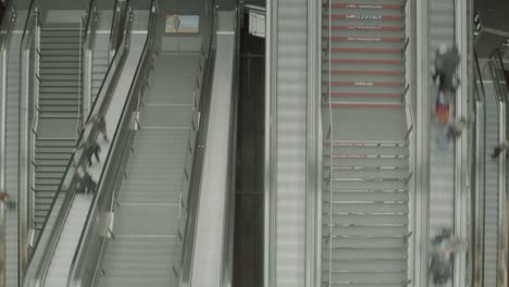 travelers use escalators to go to various levels at busy train station