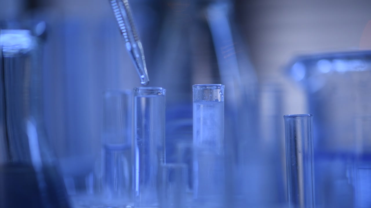 Scientific Experiment with Pipette Dropping Liquid into Test Tube