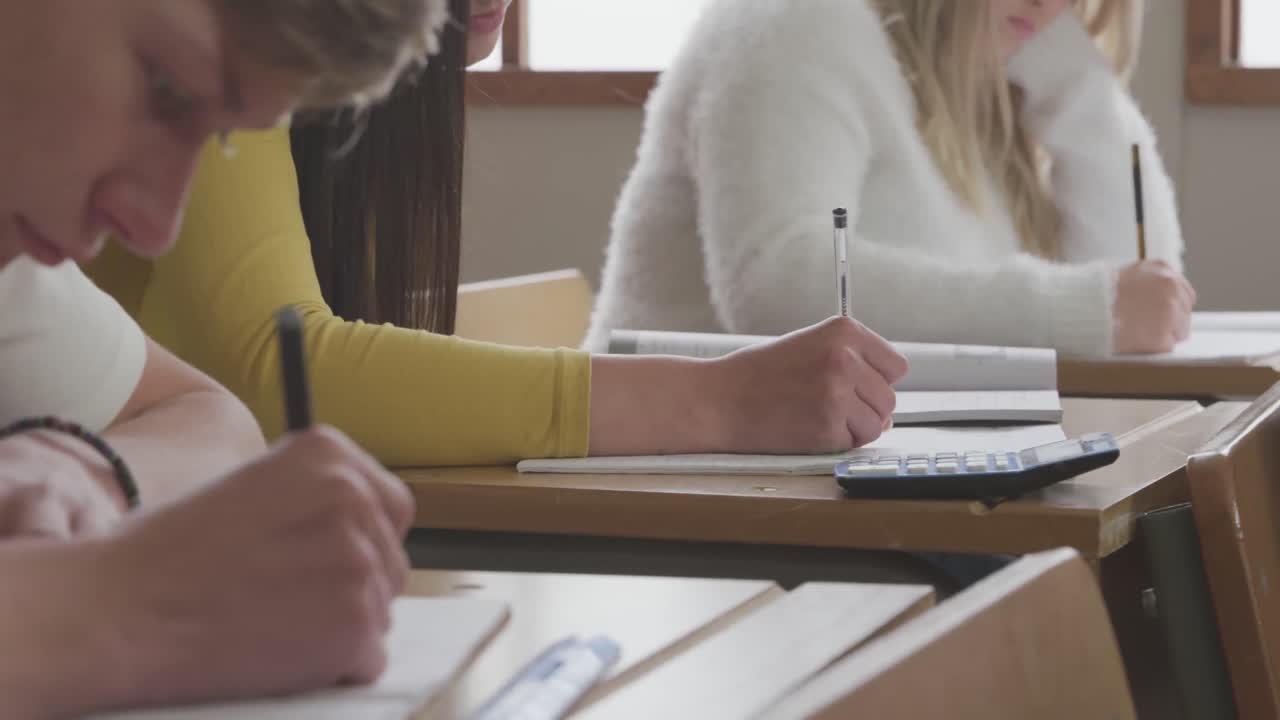 estudiantes que escriben en la clase de secundaria