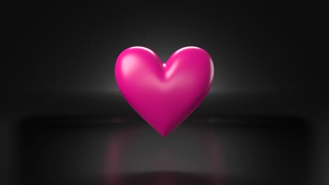 objeto en forma de corazón rosado pulsante sobre fondo negro.