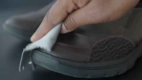 man cleaning brown leather shoes