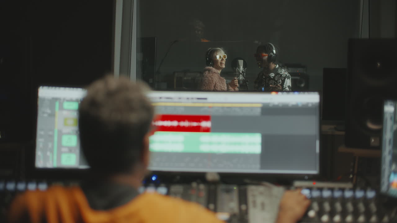 Two Musicians Recording Song in Professional Audio Studio with Sound Engineer