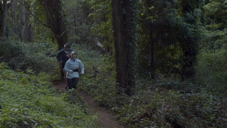 male and female athletes with headlights running in forest