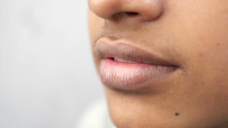 primer plano de la boca y los labios de una mujer, mostrando dientes y detalles de la piel