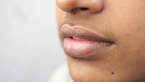 close-up of a woman's mouth and lips, showing teeth and skin detail